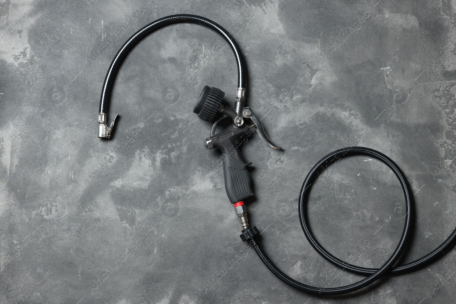 One tire inflation gun with gauge on grey background, top view Photo of One tire inflation gun with gauge on grey background, top view