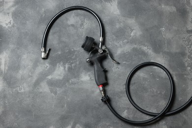 Photo of One tire inflation gun with gauge on grey background, top view