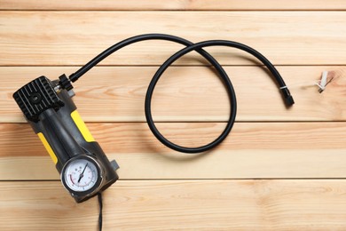 Photo of One modern tire inflator on wooden background, top view