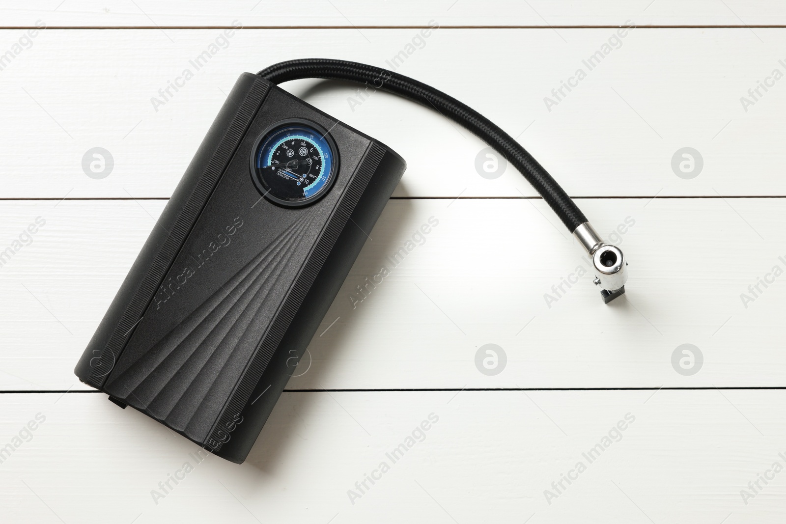 One modern tire inflator on white wooden background, top view Photo of One modern tire inflator on white wooden background, top view