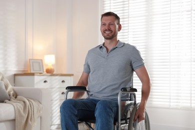 Photo of Happy man in modern wheelchair at home