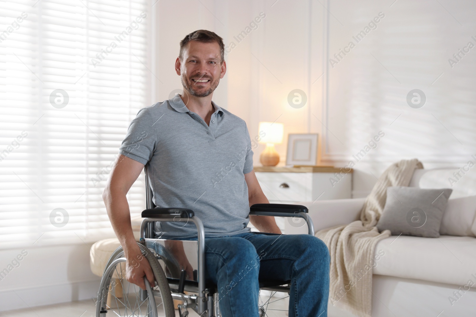 Photo of Happy man in modern wheelchair at home