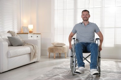 Photo of Happy man in modern wheelchair at home, space for text