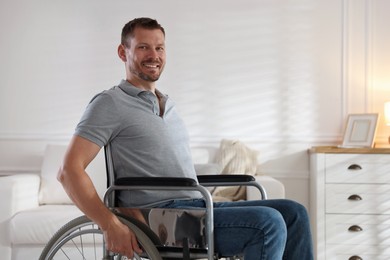 Photo of Happy man in modern wheelchair at home