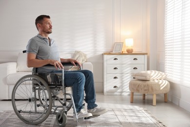 Photo of Man in modern wheelchair at home, space for text