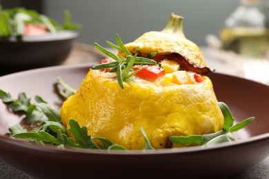 Photo of Tasty stuffed pattypan squash with arugula on grey table, closeup