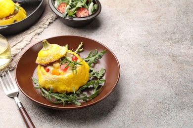 Photo of Tasty stuffed pattypan squash with arugula served on grey table. Space for text