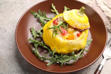 Photo of Tasty stuffed pattypan squash with arugula served on grey table, closeup