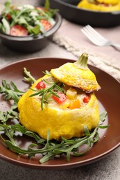 Photo of Tasty stuffed pattypan squash with arugula on grey table, closeup