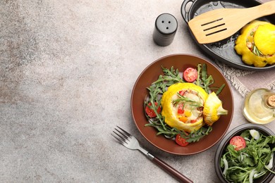 Photo of Tasty stuffed pattypan squash with tomatoes and arugula served on grey table, flat lay. Space for text