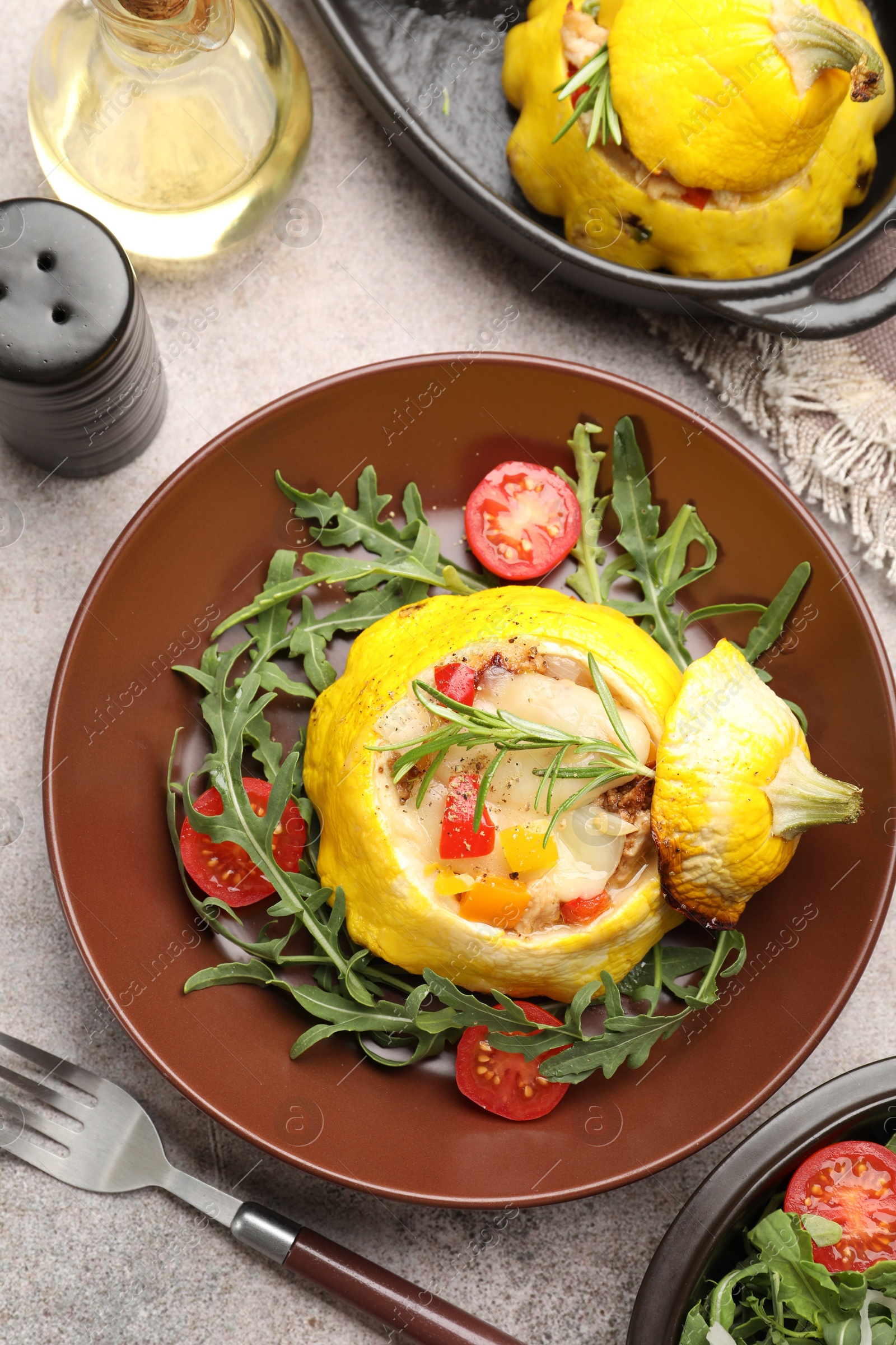 Photo of Tasty stuffed pattypan squash with tomatoes and arugula served on grey table, flat lay