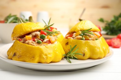 Photo of Tasty stuffed pattypan squashes on white wooden table, closeup