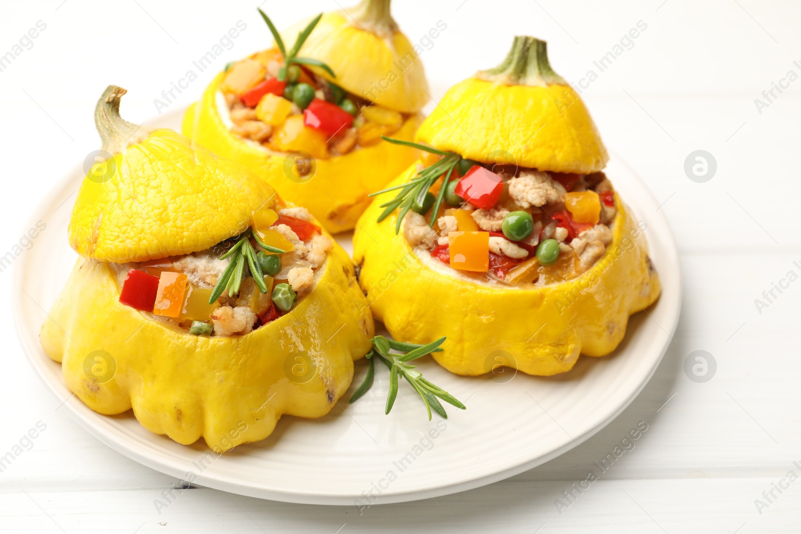 Photo of Tasty stuffed pattypan squashes on white wooden table, closeup