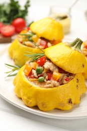 Photo of Tasty stuffed pattypan squashes on white table, closeup