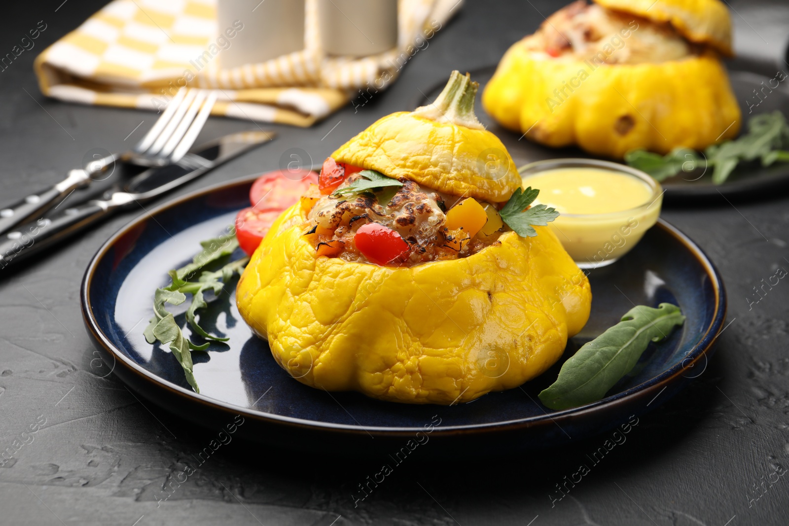 Tasty stuffed pattypan squash with sauce on black table, closeup Photo of Tasty stuffed pattypan squash with sauce on black table, closeup