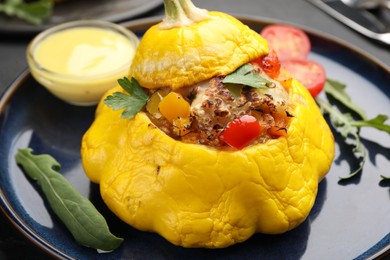 Photo of Tasty stuffed pattypan squash with sauce on black table, closeup