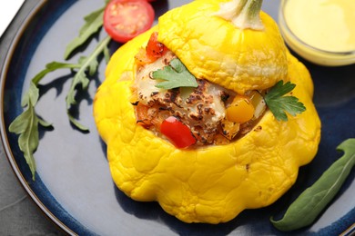 Photo of Tasty stuffed pattypan squash with sauce on black table, closeup