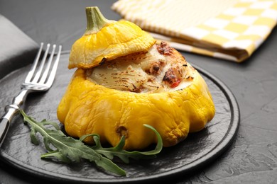 Photo of Tasty stuffed pattypan squash served on black table, closeup