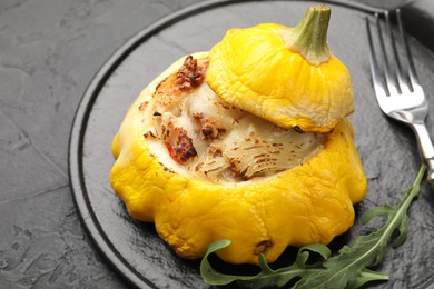 Photo of Tasty stuffed pattypan squash served on black table, closeup