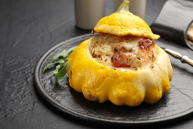 Photo of Tasty stuffed pattypan squash on black table, closeup