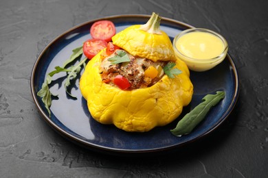 Photo of Tasty stuffed pattypan squash on black table, closeup