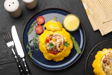Photo of Tasty stuffed pattypan squash served on black table, flat lay