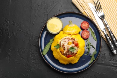 Photo of Tasty stuffed pattypan squash served on black table, flat lay. Space for text