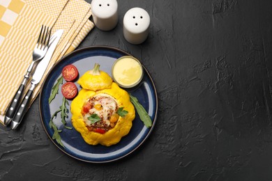 Photo of Tasty stuffed pattypan squash served on black table, flat lay. Space for text
