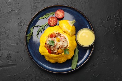 Photo of Tasty stuffed pattypan squash on black table, top view