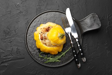 Photo of Tasty stuffed pattypan squash served on black table, top view