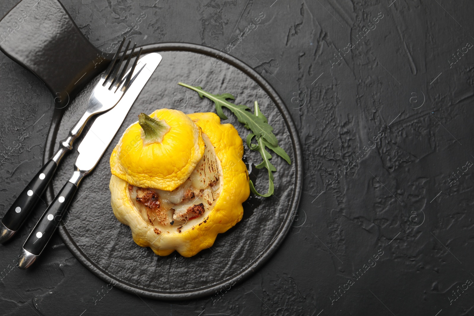 Photo of Tasty stuffed pattypan squash served on black table, top view. Space for text