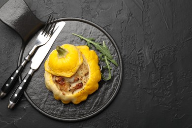 Photo of Tasty stuffed pattypan squash served on black table, top view. Space for text