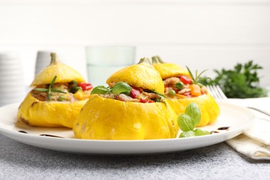 Photo of Tasty stuffed pattypan squashes served on grey table, closeup