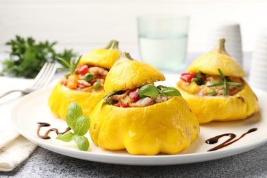Photo of Tasty stuffed pattypan squashes on grey table, closeup