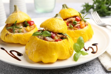 Photo of Tasty stuffed pattypan squashes on grey table, closeup
