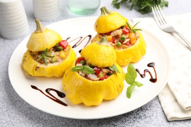 Photo of Tasty stuffed pattypan squashes served on grey table, closeup