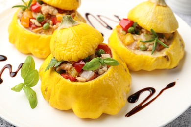 Photo of Tasty stuffed pattypan squashes on grey table, closeup