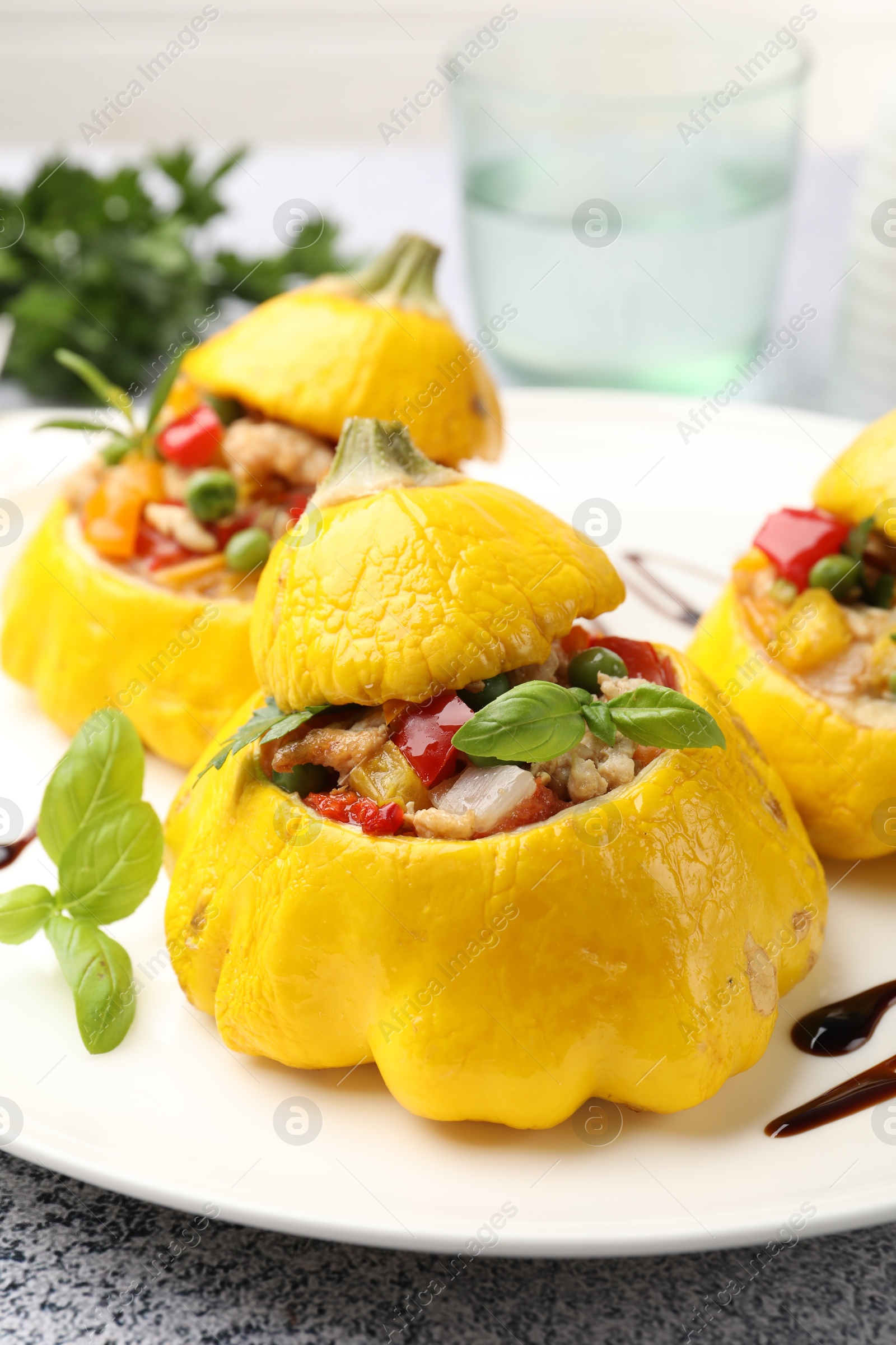 Photo of Tasty stuffed pattypan squashes on grey table, closeup
