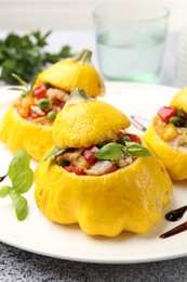 Photo of Tasty stuffed pattypan squashes on grey table, closeup