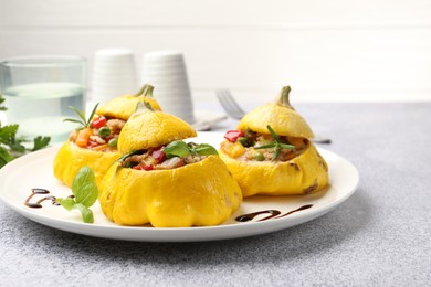 Photo of Tasty stuffed pattypan squashes on grey table, closeup