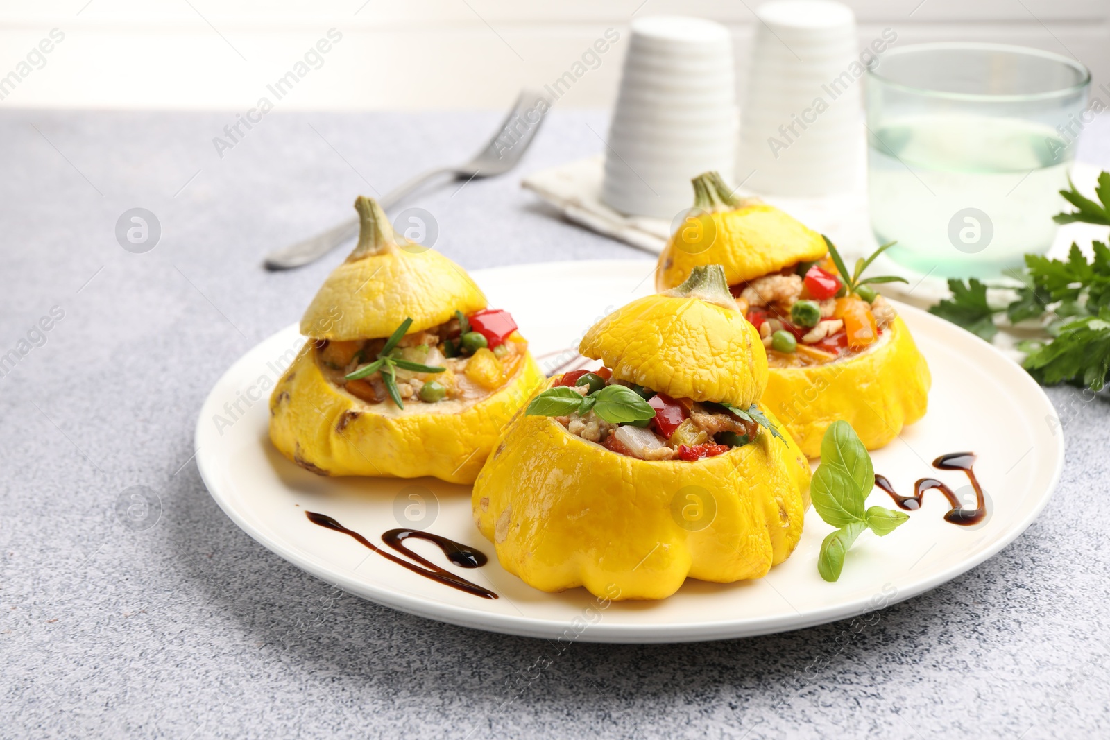 Photo of Tasty stuffed pattypan squashes on grey table, closeup