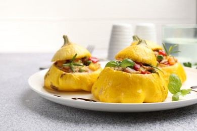 Photo of Tasty stuffed pattypan squashes on grey table, closeup