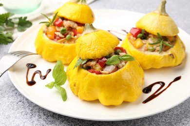 Photo of Tasty stuffed pattypan squashes on grey table, closeup