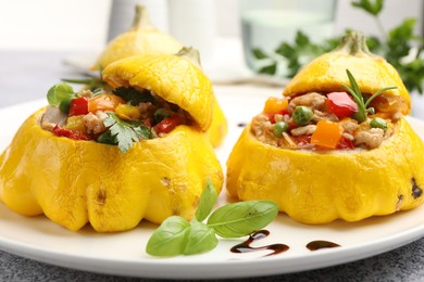 Photo of Tasty stuffed pattypan squashes on grey table, closeup