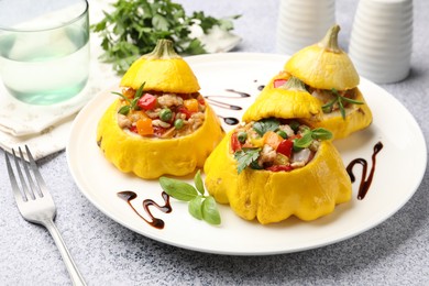 Photo of Tasty stuffed pattypan squashes served on grey table, closeup