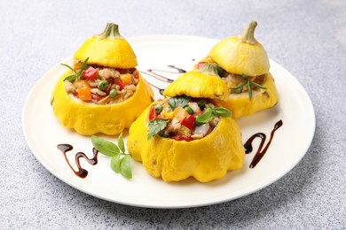 Photo of Tasty stuffed pattypan squashes on grey table, closeup