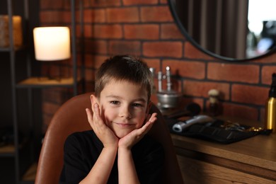 Photo of Portrait of cute little boy in barbershop