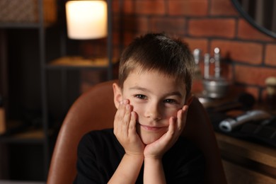 Photo of Portrait of cute little boy in barbershop