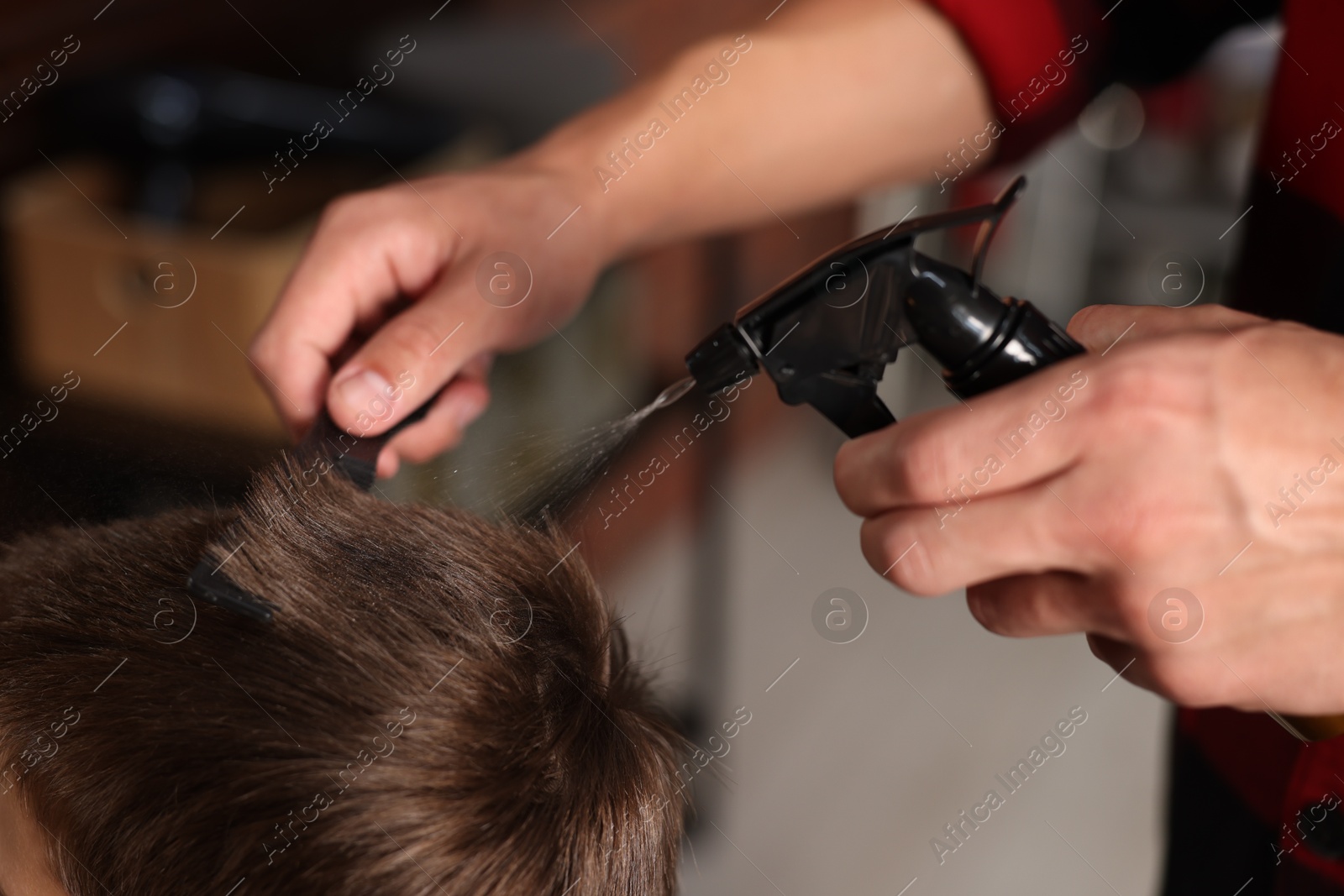 Professional barber working with little boy in barbershop, closeup Photo of Professional barber working with little boy in barbershop, closeup