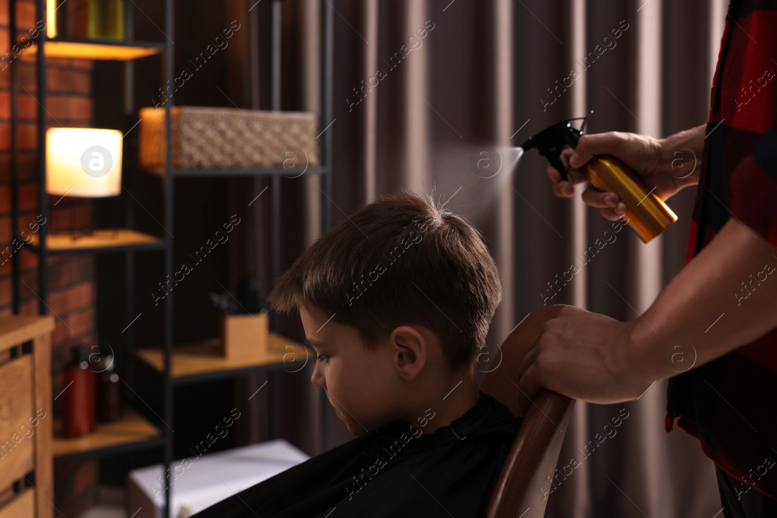Professional barber working with little boy in barbershop, closeup Photo of Professional barber working with little boy in barbershop, closeup